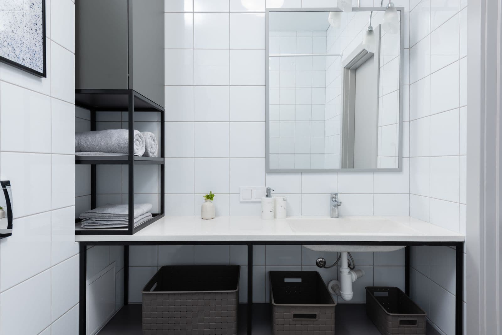 Spotless white-tile bathroom with a polished mirror, streak-free after a deep clean