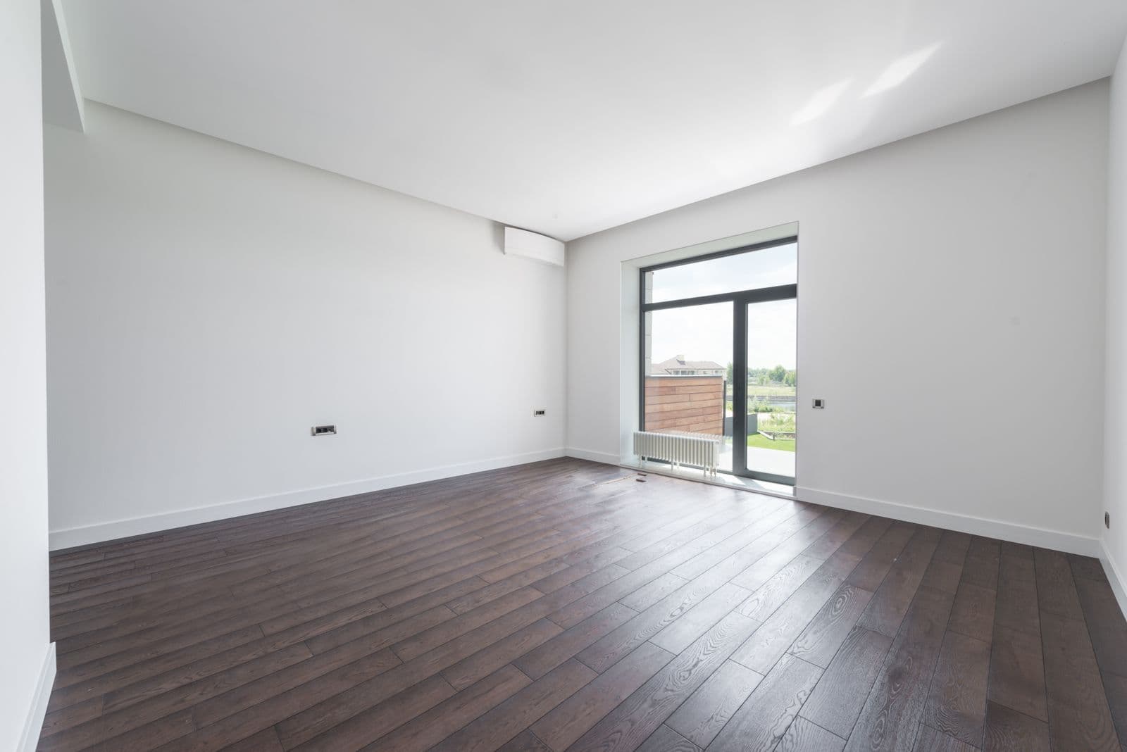 Empty apartment room with parquet flooring and a bright window on moving day