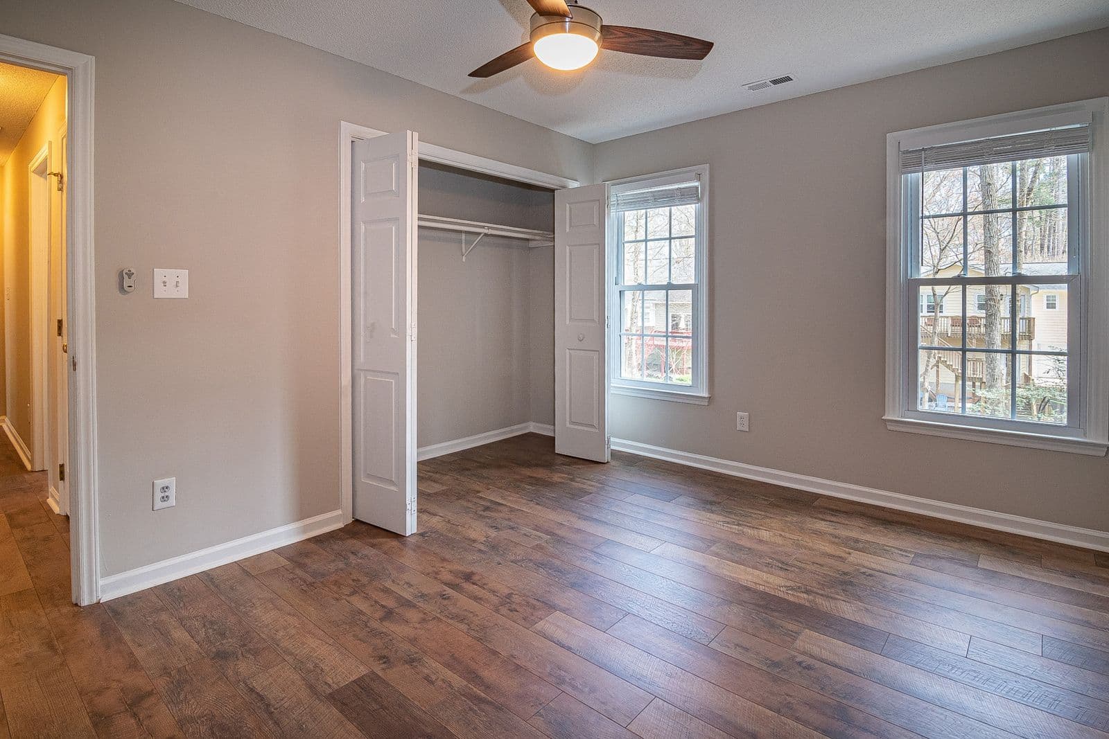 Empty bedroom with wooden floor and an open closet, ready to be cleaned
